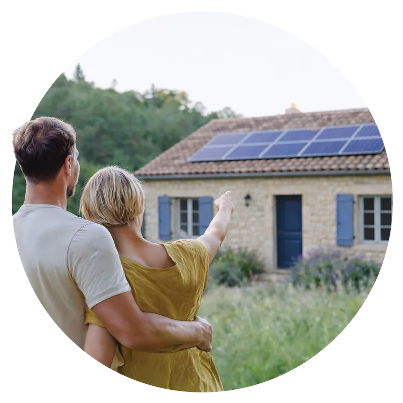 Famille sur le pas de sa porte devant une maison équipée de panneaux solaires
